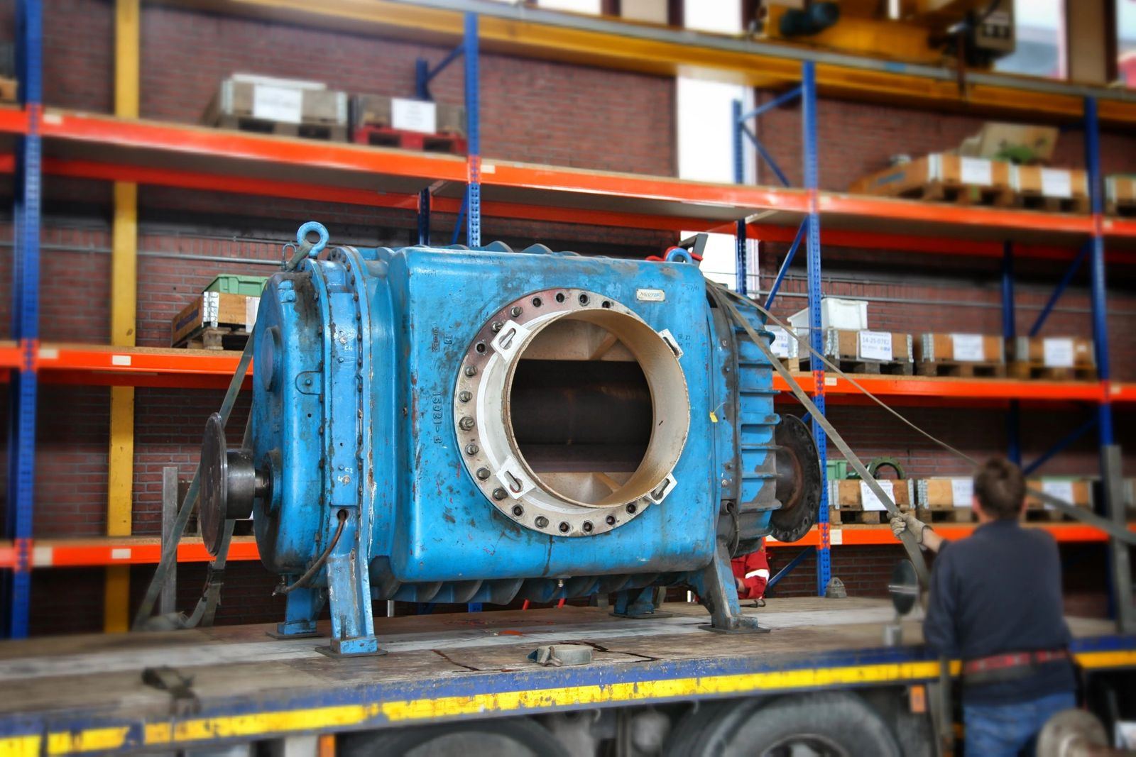 Large blue pump casing mounted on a stand inside the repair workshop