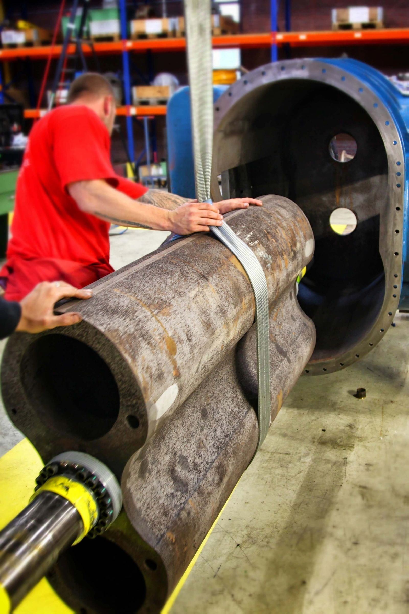 IES technician handling a large shaft inside the Pasadena repair facility